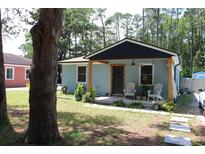 Charming blue cottage featuring a cozy front porch with adirondack chairs and lovely landscaping at 1600 Beaver Rd., Myrtle Beach, SC 29577