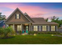 Charming single-Gathering home featuring a manicured lawn and a welcoming front porch with stone accents at 1715 Lake Egret Dr., North Myrtle Beach, SC 29582