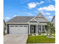 Charming single-story home featuring a two-car garage, landscaped yard, and inviting front porch at 1898 Moonseed Dr., Longs, SC 29568