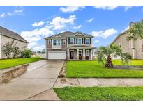 Charming two-story home with a manicured lawn, a two-car garage, and a welcoming front porch at 209 Haley Brooke Dr., Conway, SC 29526