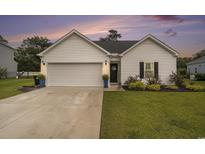 Charming one-story home with a well-maintained lawn, a two-car garage, and tasteful landscaping at 247 Grove Park Grove Park Loop, Murrells Inlet, SC 29576