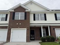 Charming two-story home with brick accents, white siding, and attached garage, set beneath a cloudy sky at 256 Connemara Dr. # 13-C, Myrtle Beach, SC 29579