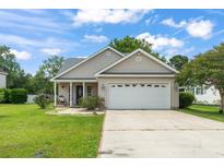 Charming single-story home with a two-car garage, well-manicured lawn, and inviting front porch at 2738 Canvasback Trail, Myrtle Beach, SC 29588