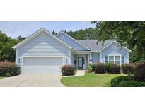 Charming single-story home with a two-car garage, manicured lawn, and inviting curb appeal at 309 Outboard Dr., Murrells Inlet, SC 29576