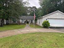 Charming one-story brick home with well-manicured lawn and mature trees at 318 Muirfield Rd., Myrtle Beach, SC 29588