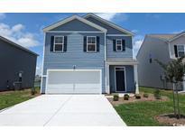 Charming two-story home showcasing a blue facade, complemented by a well-manicured lawn and an integrated two-car garage at 3657 Bells Lake Circle, Longs, SC 29568