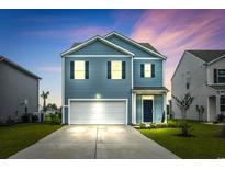 Charming two-story home with blue siding, a two-car garage, and well-manicured landscaping at 3657 Bells Lake Circle, Longs, SC 29568