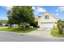 Charming single-story home featuring a manicured lawn and a two-car attached garage at 402 Bristlecone St., Longs, SC 29568