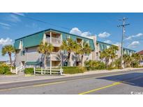 Coastal condo building featuring palm trees and balconies under a bright blue sky at 4201 N Ocean Blvd. # Ocean View, Myrtle Beach, SC 29572
