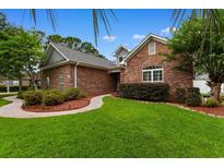 Charming single-story brick home with a manicured front yard and beautiful landscaping at 4228 Friendfield Trace, Little River, SC 29566