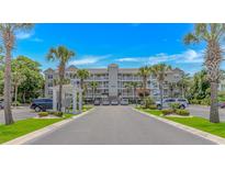 Condo complex with palm trees, manicured landscaping, and a parking lot with multiple cars parked at 4366 Rivergate Ln. # 306, Little River, SC 29566