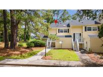 Charming townhome with a well-maintained lawn and inviting entryway staircase and yellow siding at 482 Greenview Dr. # 5B, Johnsonville, SC 29555