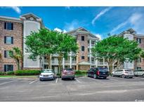Condo exterior with brick accents, white trim, mature trees, and convenient parking at 4894 Luster Leaf Circle # 403, Myrtle Beach, SC 29577