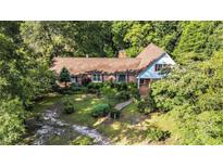 Charming home nestled amongst mature trees with a well-manicured yard and a brick walkway leading to the front door at 4920 Meadow St., Loris, SC 29569