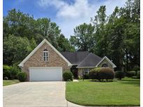 Charming brick home with a well-manicured lawn and mature trees in a serene setting at 6542 Wellington Dr., Murrells Inlet, SC 29576