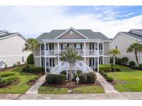 Inviting condo with a lush landscape and white staircases leading to the covered porches at 964 Great Egret Circle Sw # B, Sunset Beach, NC 28468