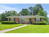 Charming brick home with a well-maintained lawn, lush green landscaping, and inviting walkway, perfect for families at 1008 N Withlacoochee Ave., Marion, SC 29571