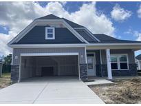New construction two-story home with a two-car garage featuring stone accents and a modern design at 1010 Black Locust Pl., Longs, SC 29568