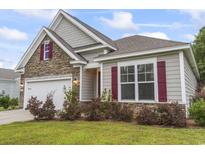 Charming home exterior with stone accents, gray siding, red shutters, and well-manicured landscaping at 124 Castaway Key Dr., Pawleys Island, SC 29585