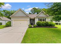 Charming single-story home featuring a well-maintained lawn, attached garage, and lovely curb appeal at 124 Shady Arbor Loop, Longs, SC 29568