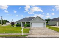 Charming one-story home features a manicured lawn and attached two-car garage at 1304 Marley St., Conway, SC 29527