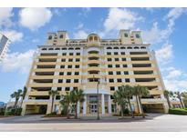 Elegant condo building featuring a parking garage and palm trees near the entrance at 2000 N Ocean Blvd. # 1810, Myrtle Beach, SC 29577