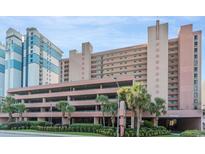 Multi-story exterior of condo with parking garage and palm trees offers beach access at 2207 S Ocean Blvd. # 718, Myrtle Beach, SC 29577