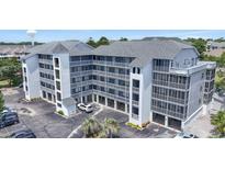 Lovely multi-story condo building showcasing multiple units and covered parking spaces at 305 Hillside Dr. N # 205, North Myrtle Beach, SC 29582