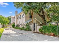 Stunning home featuring a stucco exterior, metal roof accents, gated entrance, and mature landscaping at 3597 Sunfish St., Murrells Inlet, SC 29576