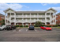 Three story condo building with multiple balconies and covered parking at 3951 Gladiola Ct. # 104, Myrtle Beach, SC 29588