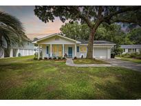 Charming single-story home featuring a well-manicured lawn and an inviting front porch with blue shutters at 412 Middleton Dr., Pawleys Island, SC 29585