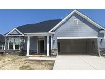 Charming single-story home features a stone facade, blue siding and an attached two-car garage at 419 White Willow Way, Longs, SC 29568