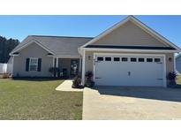 Charming single-story home features a well-manicured lawn, two-car garage, and covered front entry at 429 Oakham Dr., Conway, SC 29526