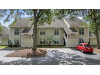 Charming exterior view of the two-story home showcasing the multiple windows and front parking at 4450 Little River Inn Ln. # 601, Little River, SC 29566