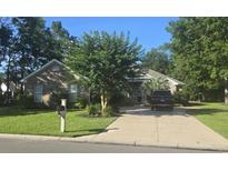 Charming brick home featuring a manicured lawn, mature trees, and a private driveway at 4499 Firethorne Dr., Murrells Inlet, SC 29576