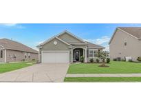 Charming single-story home featuring an attached garage, well-maintained lawn, and classic exterior details at 5018 Oat Fields Drive, Myrtle Beach, SC 29588