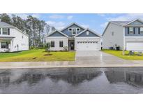Charming home with a manicured lawn, two-car garage, and stylish blue and white siding at 628 Mccorkle Place, Conway, SC 29526