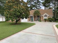 Inviting single story home with brick facade, large driveway, mature landscaping, and attached two car garage at 9614 Indigo Creek Blvd., Murrells Inlet, SC 29576