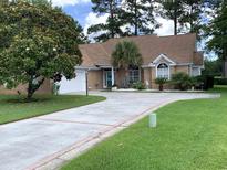 Charming single-story brick home features a long drive and well-manicured lawn at 9614 Indigo Creek Blvd., Murrells Inlet, SC 29576