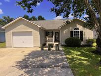 Charming single-story home featuring a one-car garage and a landscaped front yard at 9888 Conifer Ln., Murrells Inlet, SC 29576
