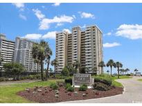 A beautiful view of the exterior of Arcadian I & II resort with well-maintained landscaping and a bright blue, cloudy sky at 10200 Beach Club Dr. # 16F, Myrtle Beach, SC 29572