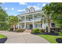 Beautiful two-story home with a charming double porch and well-manicured landscaping at 155 Preservation Circle, Pawleys Island, SC 29585