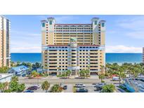 Stunning view of the yellow condo building with palm trees and access to a beautiful beach at 2000 N Ocean Blvd. # 1209, Myrtle Beach, SC 29577