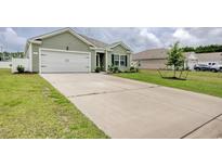 Charming one-story home featuring an attached garage, well-maintained lawn, and a spacious concrete driveway at 211 Seasons Trace Loop, Longs, SC 29568