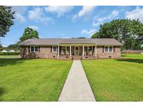 Charming brick home with a welcoming front porch and well-maintained lawn at 312 S Poplar Ave., Andrews, SC 29510