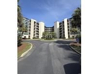 Beautiful exterior view of the condo complex featuring tropical landscaping and a roundabout driveway at 417 S Dunes Dr., Pawleys Island, SC 29585