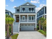 Two-story coastal home with a welcoming front porch, a two-car garage and mature landscaping at 496 West Palm Dr., Myrtle Beach, SC 29579
