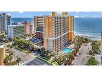Beautiful oceanfront condo building with pools, palm trees, and balconies overlooking the beach at 6900 N Ocean Blvd. # 1541, Myrtle Beach, SC 29572