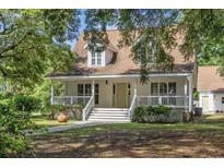 Charming home with a welcoming front porch and mature trees, offering a serene curb appeal at 7288 Schooners Ct. Sw, Ocean Isle Beach, NC 28469