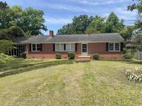 Charming brick home featuring a well-maintained lawn and classic design elements at 911 Park Ave., Marion, SC 29571